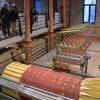 Vista general de las máquinas de hilado y urdido en el Museo Textil de Béjar, con visitantes observando desde la planta superior