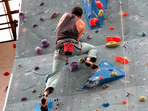 Escalador practicando en un rocódromo interior