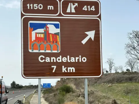 Panel turístico de Candelario instalado en la A-66 indicando el acceso al municipio a 7 kilómetros, cerca de Béjar