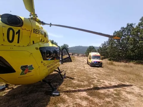 Helicóptero de rescate de Protección Civil y Emergencias de Castilla y León junto a una ambulancia en el campo de fútbol de La Alberca durante la evacuación de un senderista herido