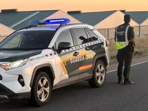 Vehículo y Agente de la Guardia Civil realizando tareas de vigilancia