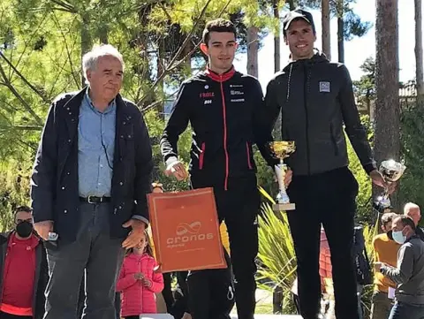 Tres personas en un pódium