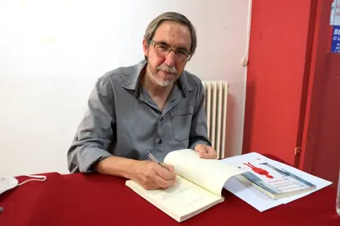 Hombre firmando un libro