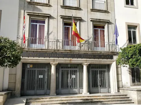 Vista parcial exterior del edificio, con tres puertas principales. Balcón con banderas