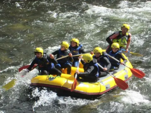 Vista parcial de uno de lso carteles promocionales, deportistas haciendo rafting