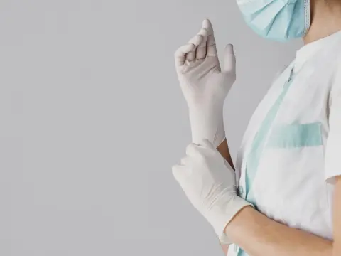 Doctor poniéndose guantes de nitrilo