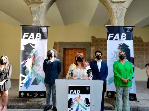 Varias personas en un patio con columnas de fondo