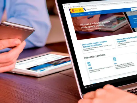 Portátil y móvil con la web de Hacienda