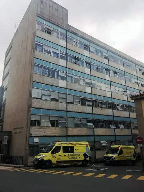 Fachada de edificio con ambulancias aparcadas