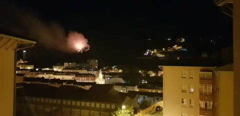 Bloques de edificios y al fondo las llamas del incendio
