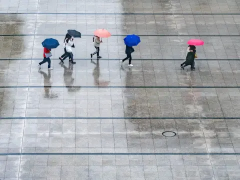 Gente bajo la lluvia con paraguas