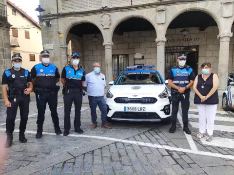 Varias personas, entre ellos 4 policías, junto al coche de policía