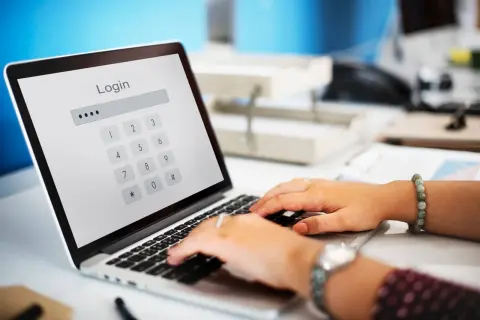 Una persona introduciendo la contraseña de acceso en un ordenador portatil