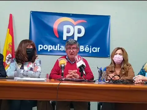 dos mujeres y un hombre sentados a una mesa