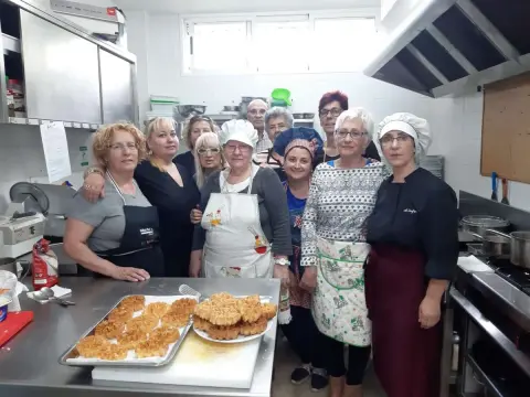 TaVarias personas en una cocina mostrando platos preparados