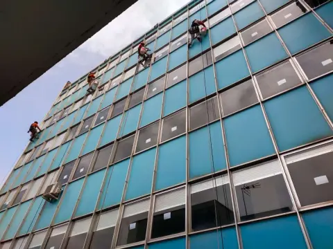 Profesionales, con equipos de trabajos en altura, trabajan en el sellado de las ventanas 